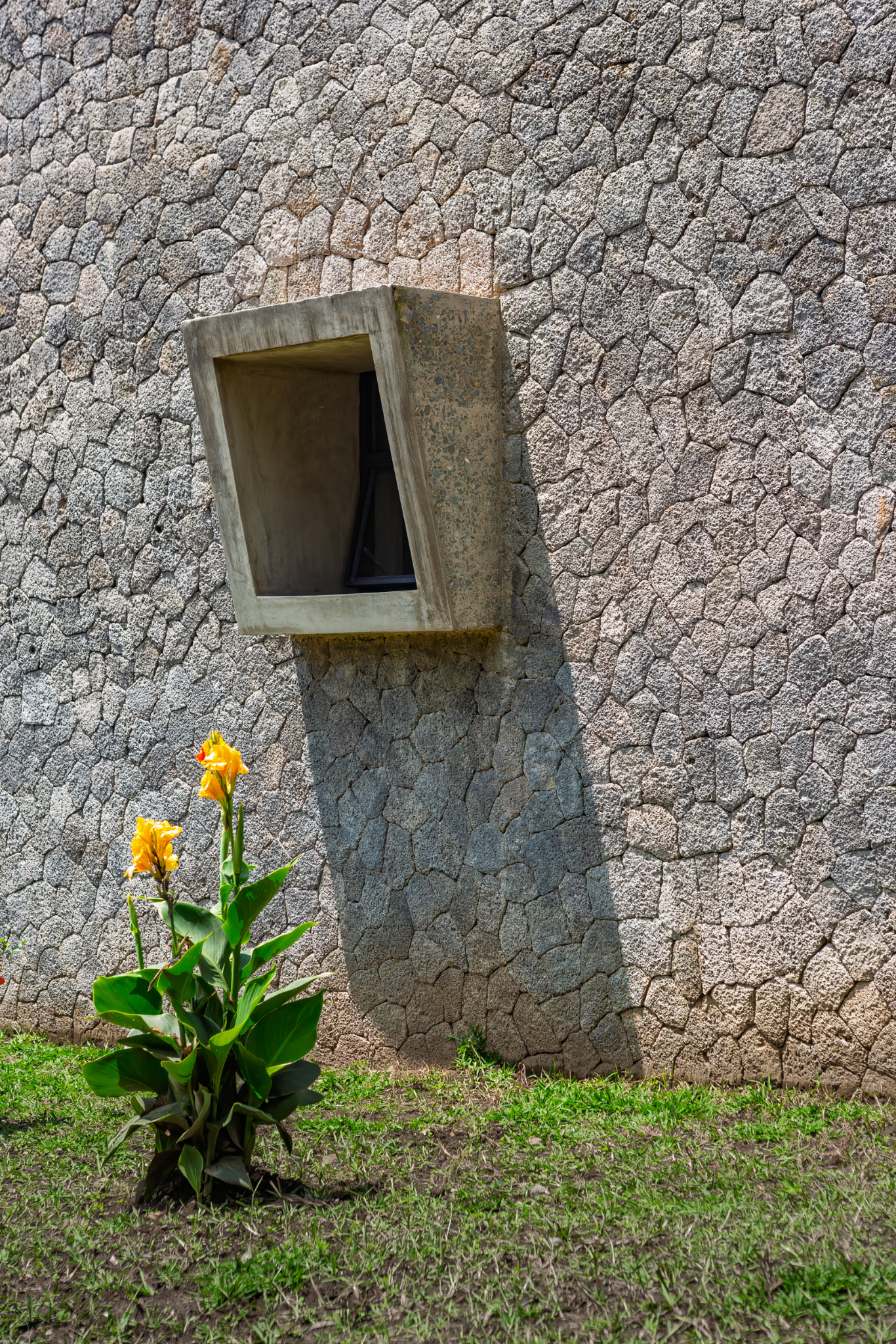 Thick volcanic rock walls enclosing the distillery, highlighting hyperlocal construction and material texture
