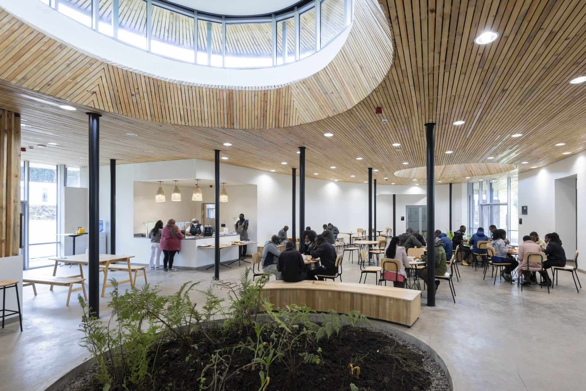 Interior gathering space with simple wood furnishings and stone surfaces