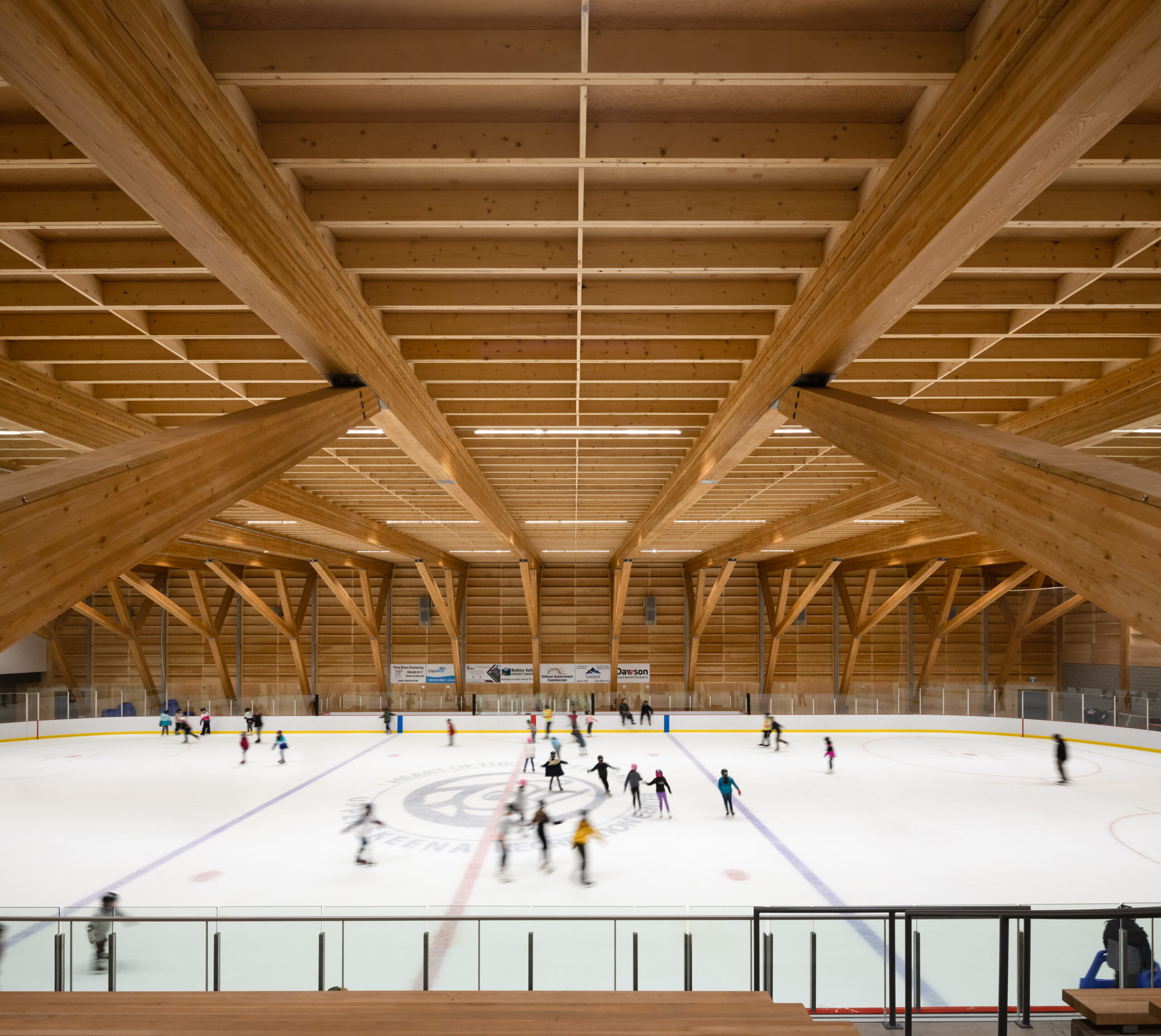 A view of skaters enjoying the ice rink below, with the stunning glulam structure spanning overhead.
