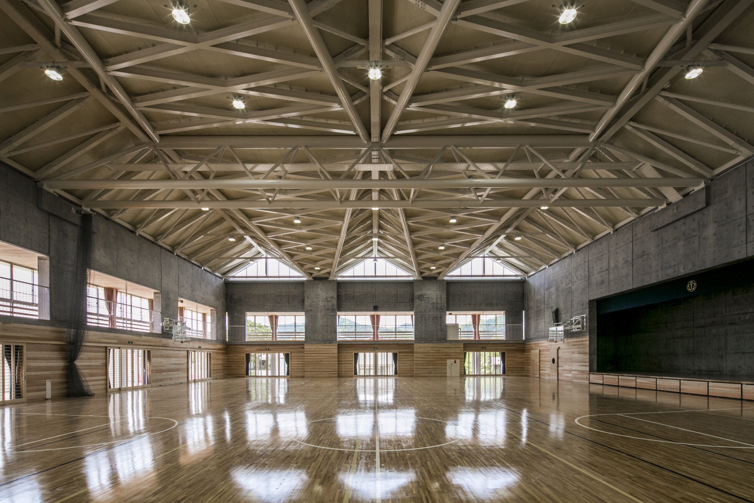A stunning view of the gym, featuring a perfect blend of concrete and wood, with a beautiful wooden brass roof structure.